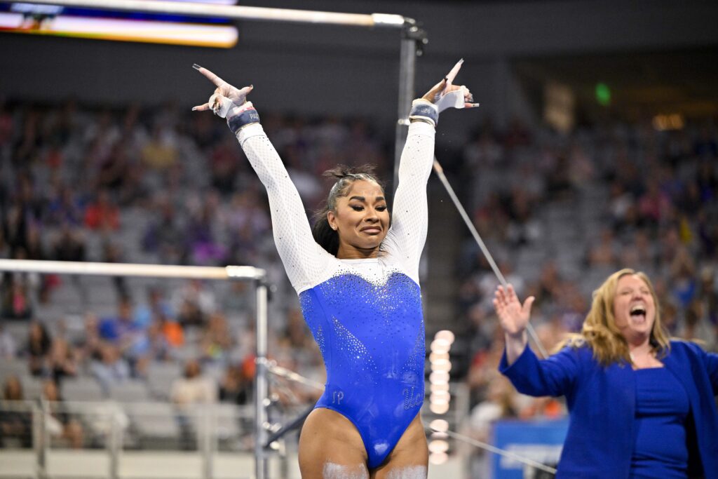 A gymnast and her coach celebrate after an uneven bars routine.