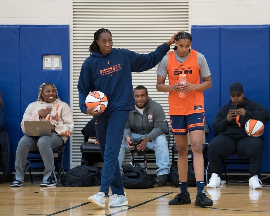 Connecticut Sun center Tina Charles (left) stands next to Connecticut Sun forward/center Rayah Marshall (right) with her hand on Marshall's head