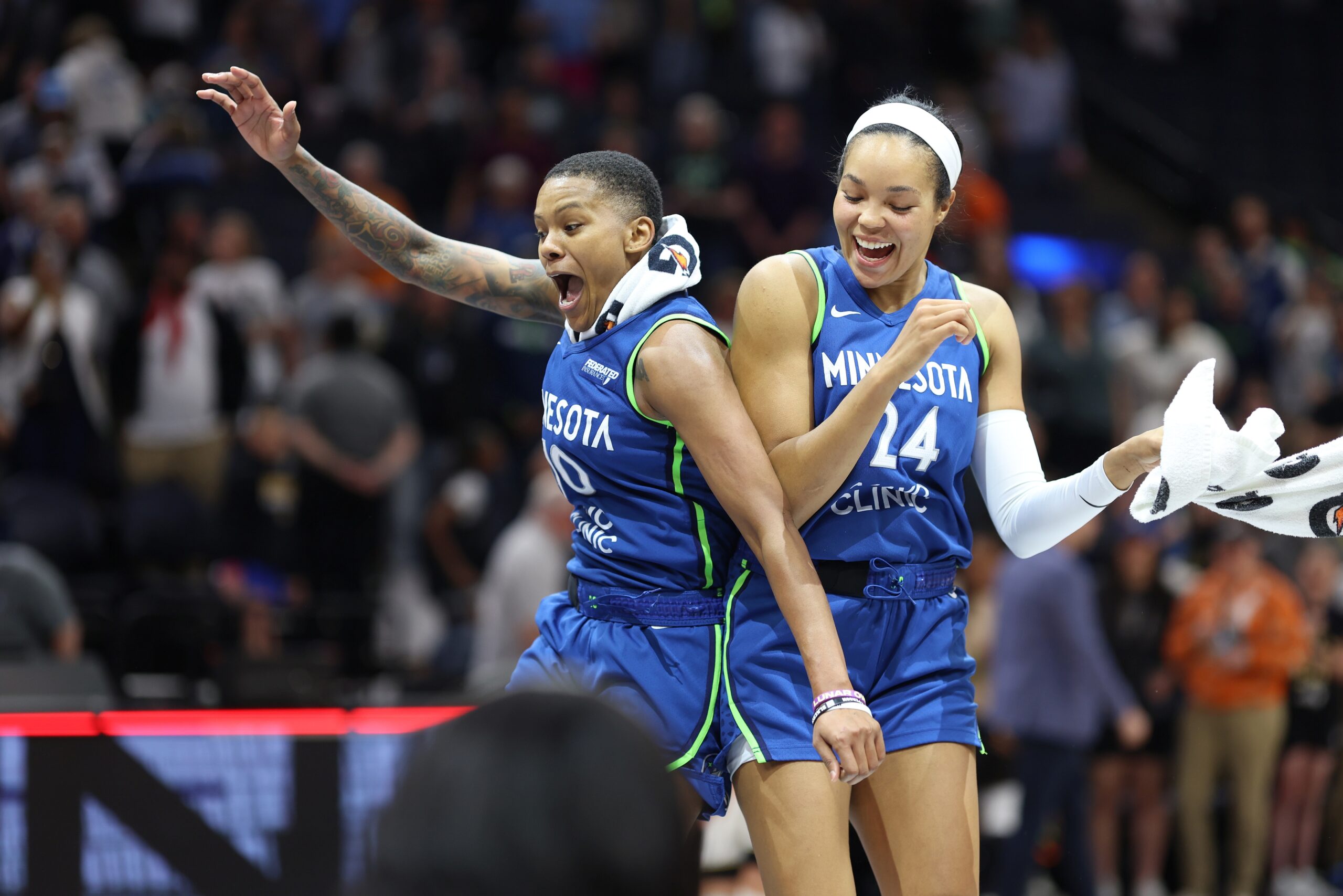 Courtney Williams (left) and Napheesa Collier (right) collide in mid-air wearing blue 'Minnesota' jerseys