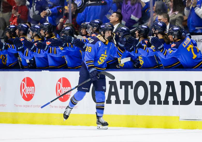 Gosling skates down the handshake line at the bench. She is wearing a blue home uniform.