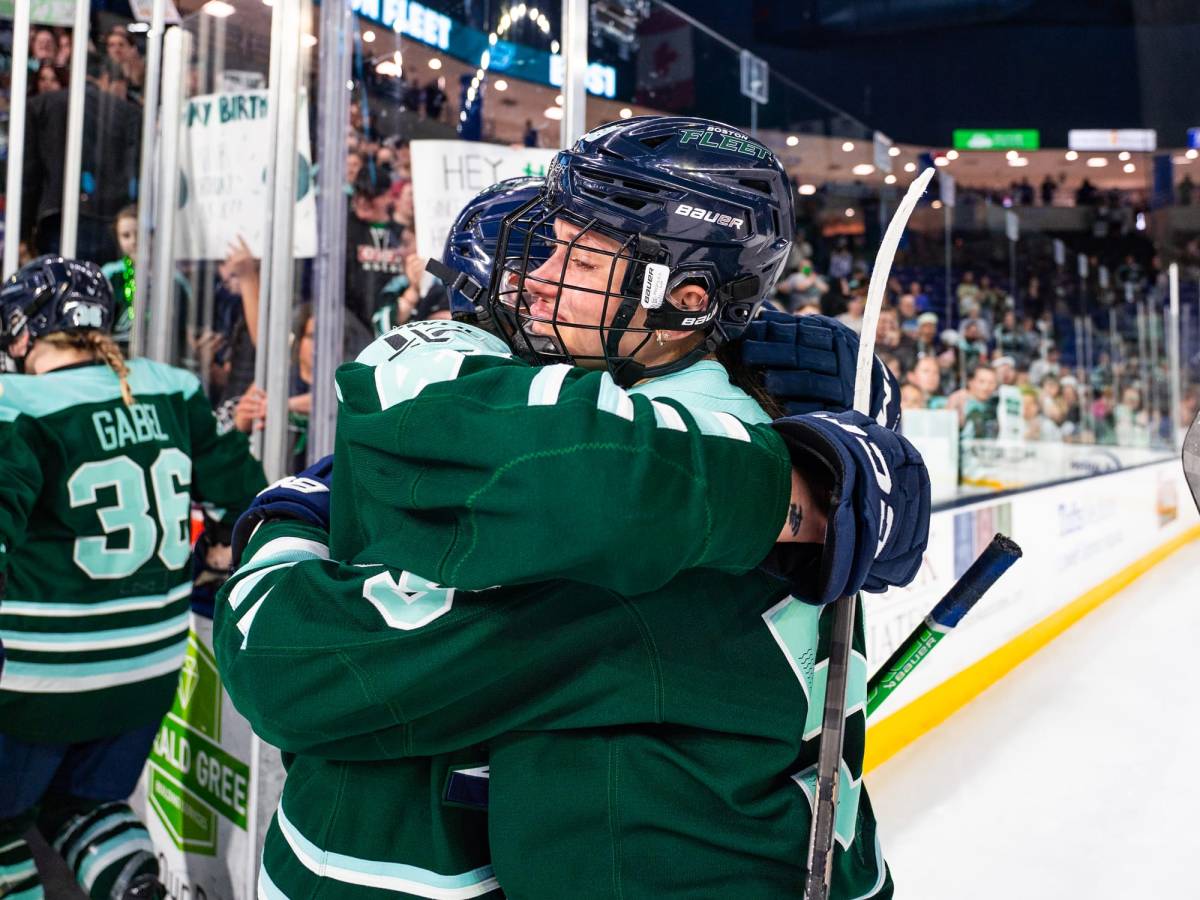 Pejšová (right) tears up as she embraces her teammate. They are both wearing green home uniforms.