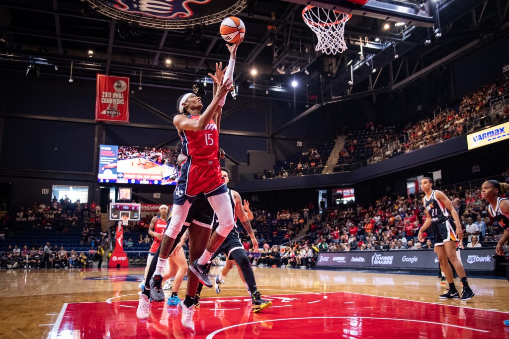 Washington Mystics guard Brittney Sykes shoots a left-handed layup on the right side of the basket. A defender reaches from behind her trying to block the shot.