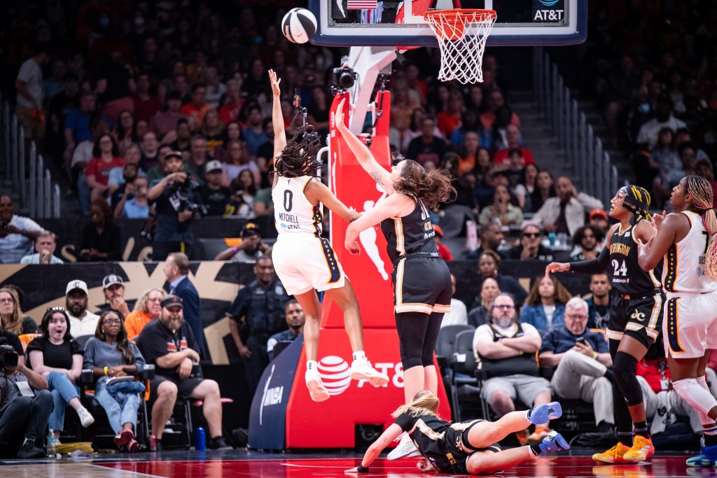 Washington Mystics center Stefanie Dolson reaches one hand up to try to contest a left-handed layup from Indiana Fever guard Kelsey Mitchell. Mystics forward Aaliyah Edwards stands next to Fever forward/center Aliyah Boston on the other side of the lane and awaits a potential rebound.