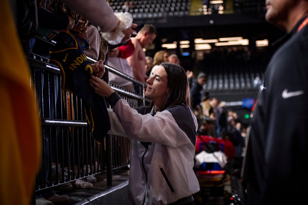 Indiana Fever guard Caitlin Clark signs a fan's Fever jersey before a game in Baltimore, Maryland.