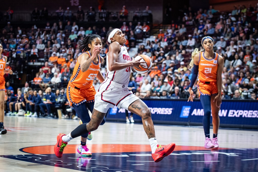 Washington Mystics guard Brittney Sykes takes a big step in the lane while holding the ball in both hands in front of her, preparing to go up for an uncontested layup.