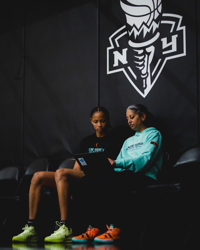 Leaonna "Neah" Odom watches film on a laptop with assistant coach Sonia Raman