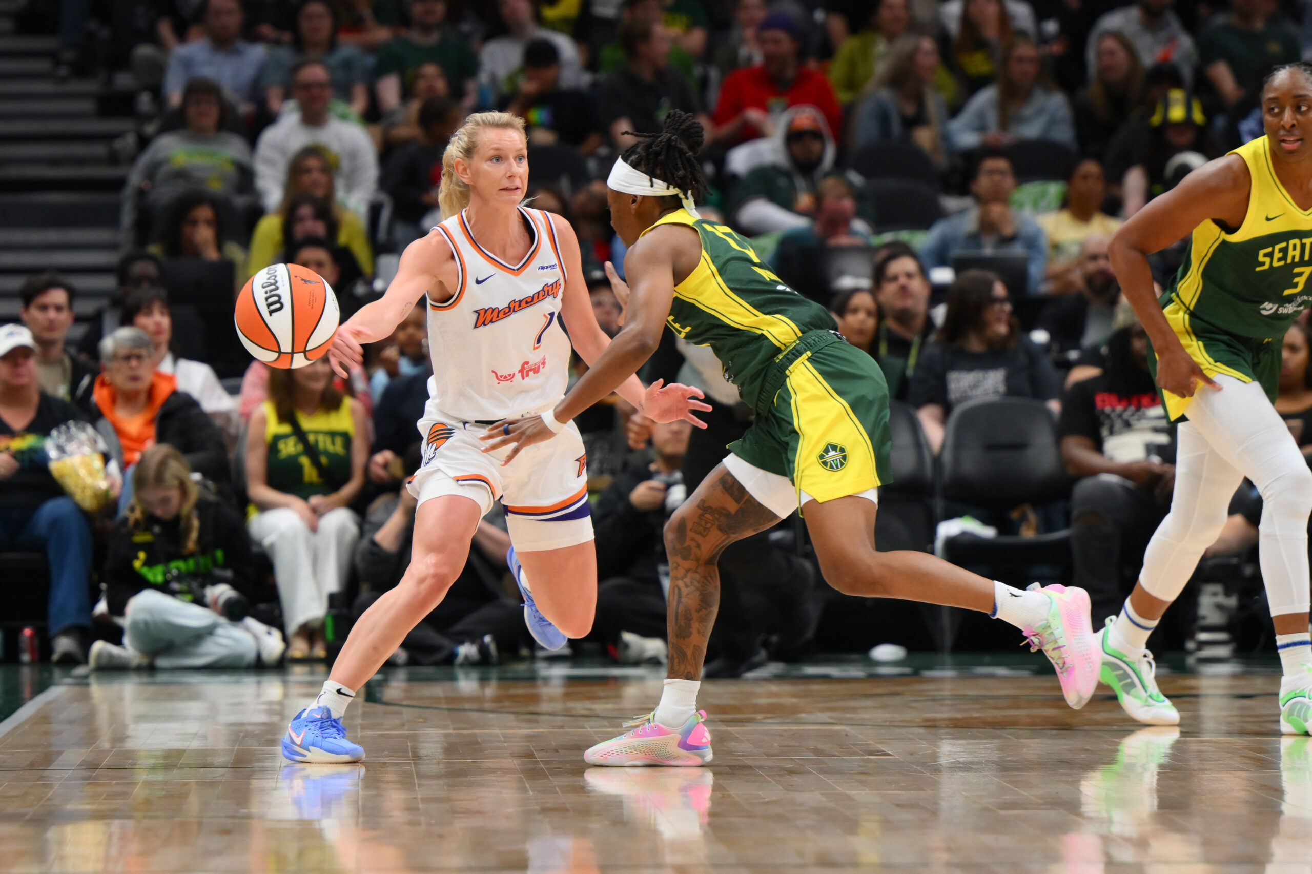 Phoenix Mercury guard Lexi Held passes up the court as she begins to cut around Seattle Storm guard Erica Wheeler, who is defending her