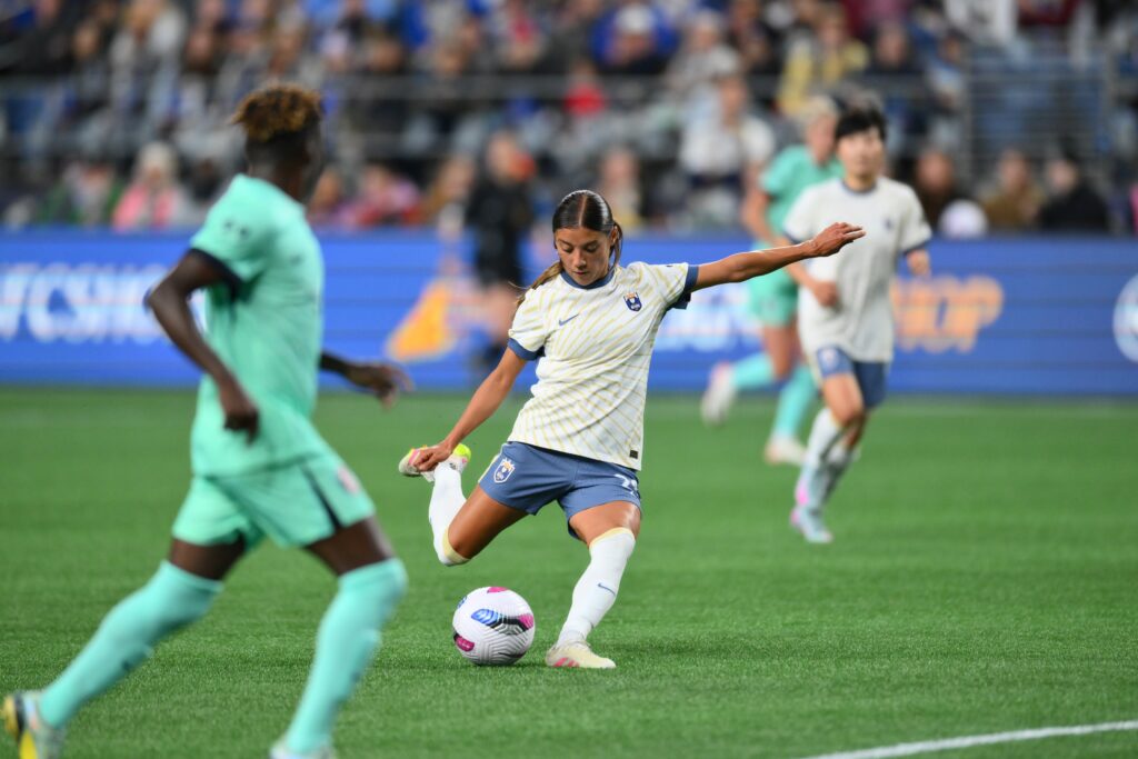 May 2, 2025; Seattle, Washington, USA; Seattle Reign midfielder Sam Meza (20) shoots the ball against the Kansas City Current during the first half at Lumen Field. Mandatory Credit: Steven Bisig-Imagn Images