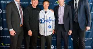 Ayami Sato smiles for a photo with Toronto Maple Leafs executives at a press conference.