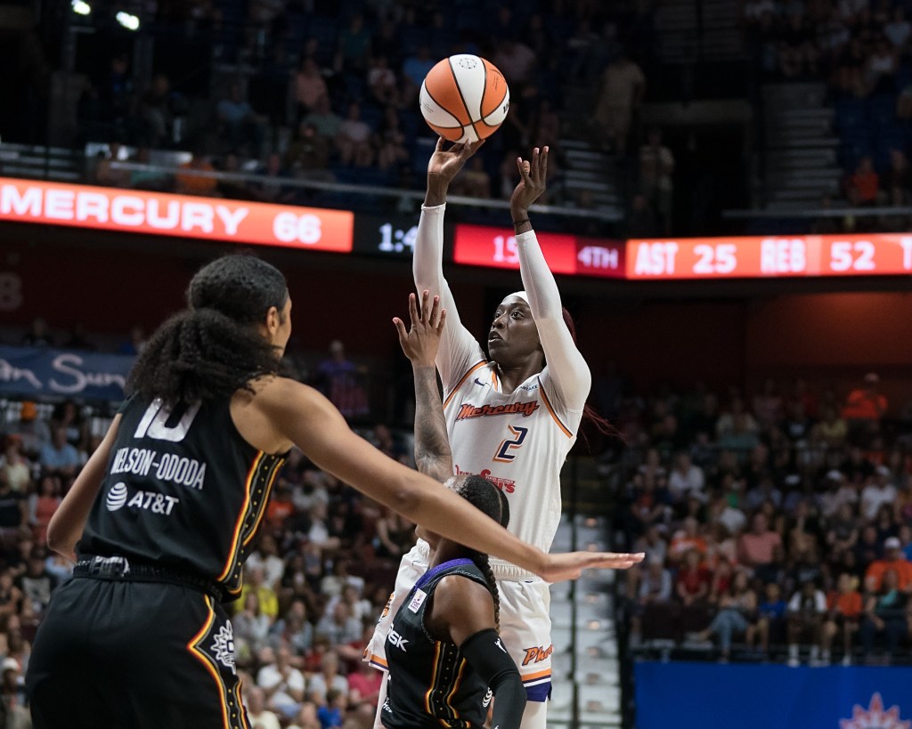 Kahleah Copper (2) shoots the ball while a Connecticut Sun player tries to contest the shot with her arm up