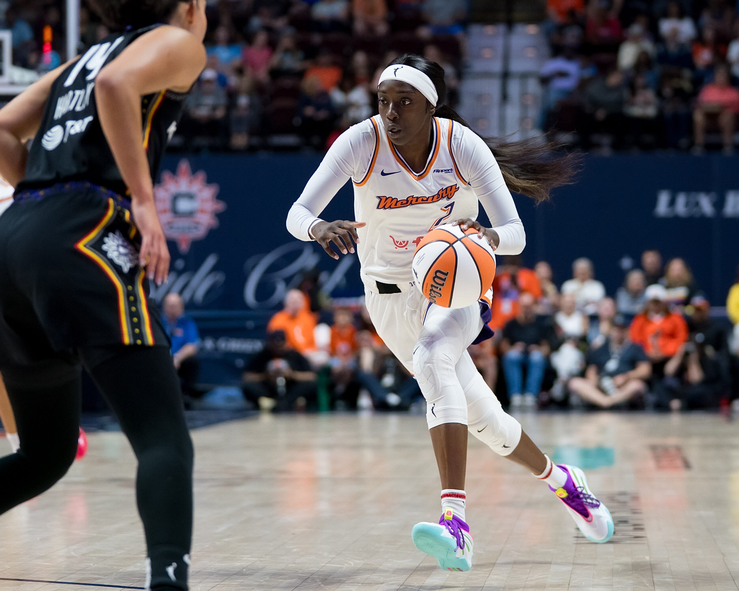 Phoenix Mercury guard/forward Kahleah Copper dribbles the ball while a Connecticut Sun player tries to defend her.