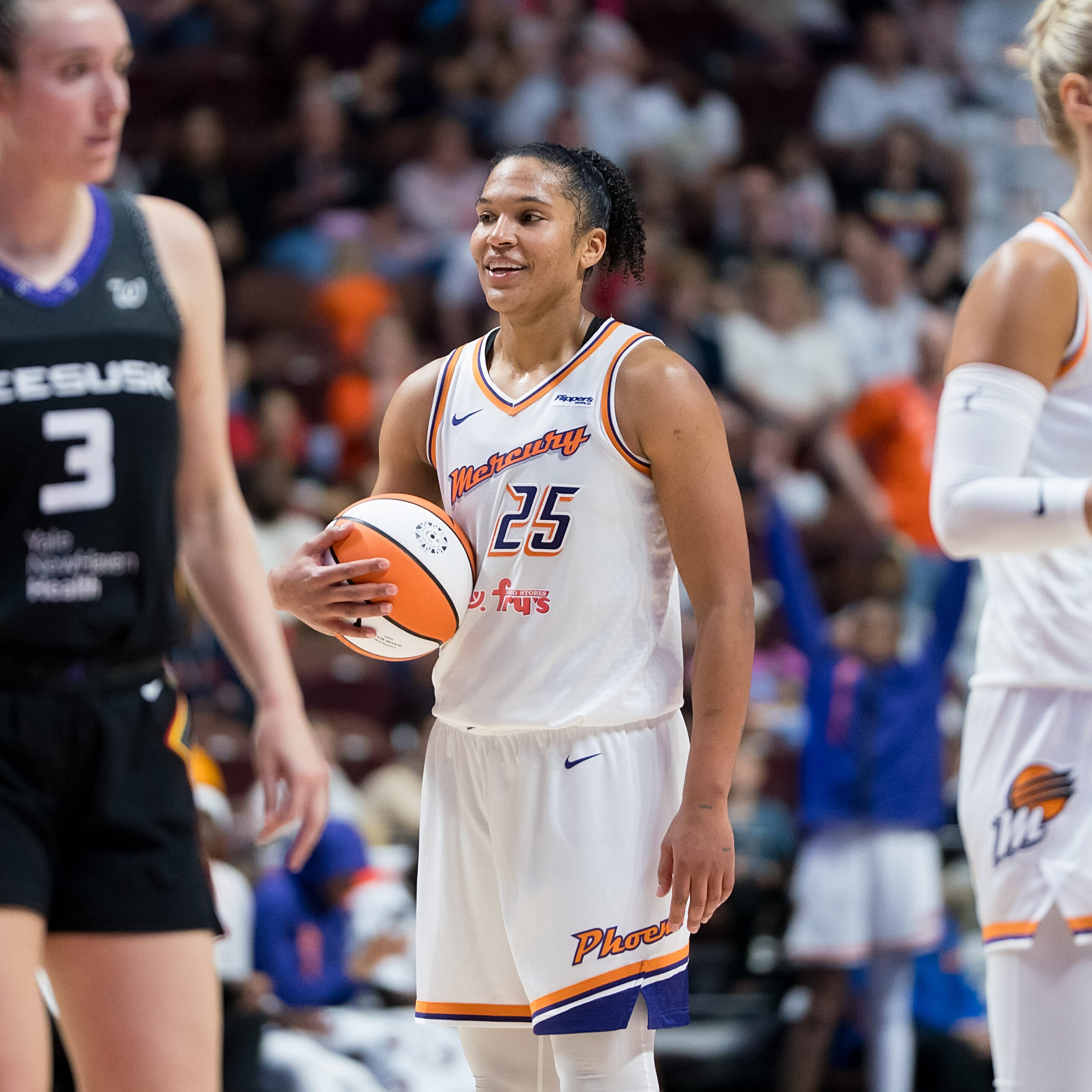 Alyssa Thomas smiles holding basketball in her hands.