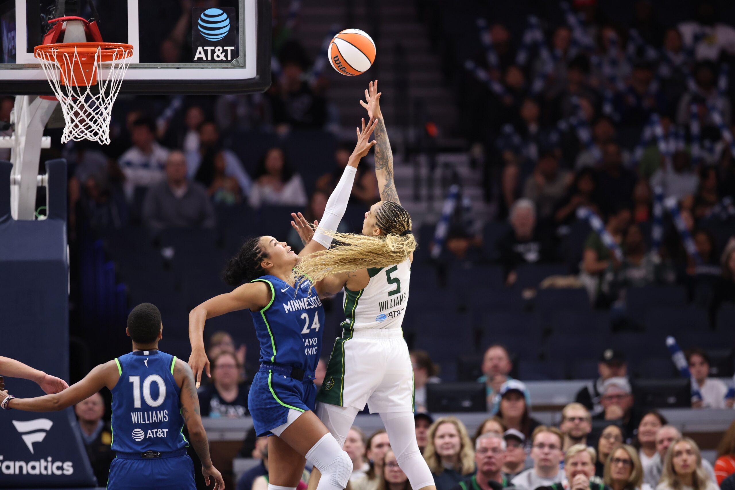 Seattle Storm forward Gabby Williams releases a layup against Minnesota Lynx forward Napheesa Collier whose arm is fully extended and hitting Williams on the wrist trying to stop her shot, in a game on May 27, 2025 at Target Center in Minneapolis, Minnesota.