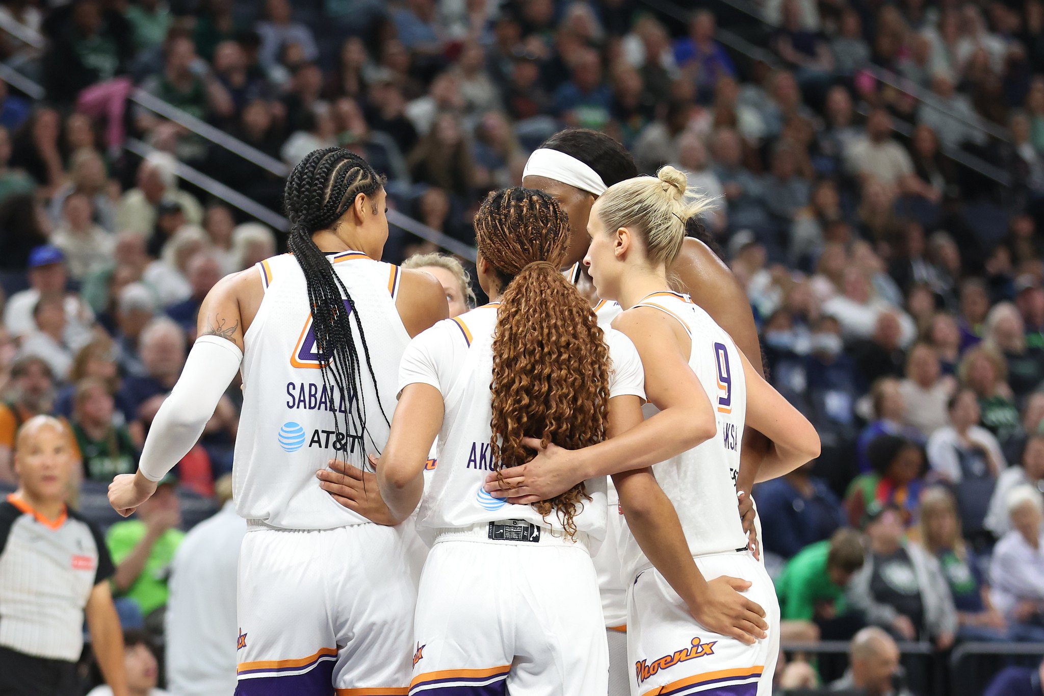 The Phoenix Mercury huddle with their arms wrapped around each other during a game against the Minnesota Lynx