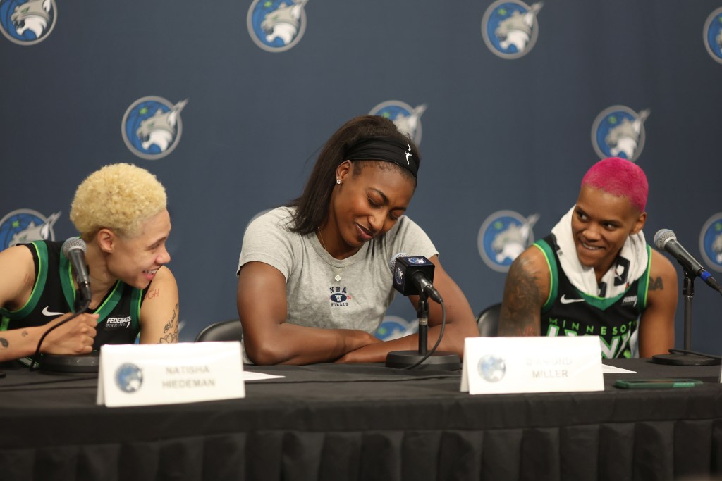 Lynx players: Natisha Hiedeman, Diamond Miller, Courtney Williams, sit in front of a blue back drop