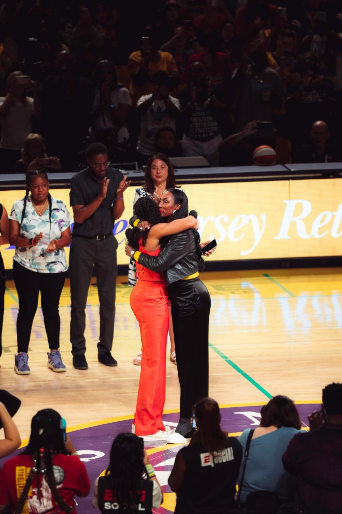 Lisa Leslie (right) hugs Candace Parker at halftime of Parker's jersey retirement ceremony.