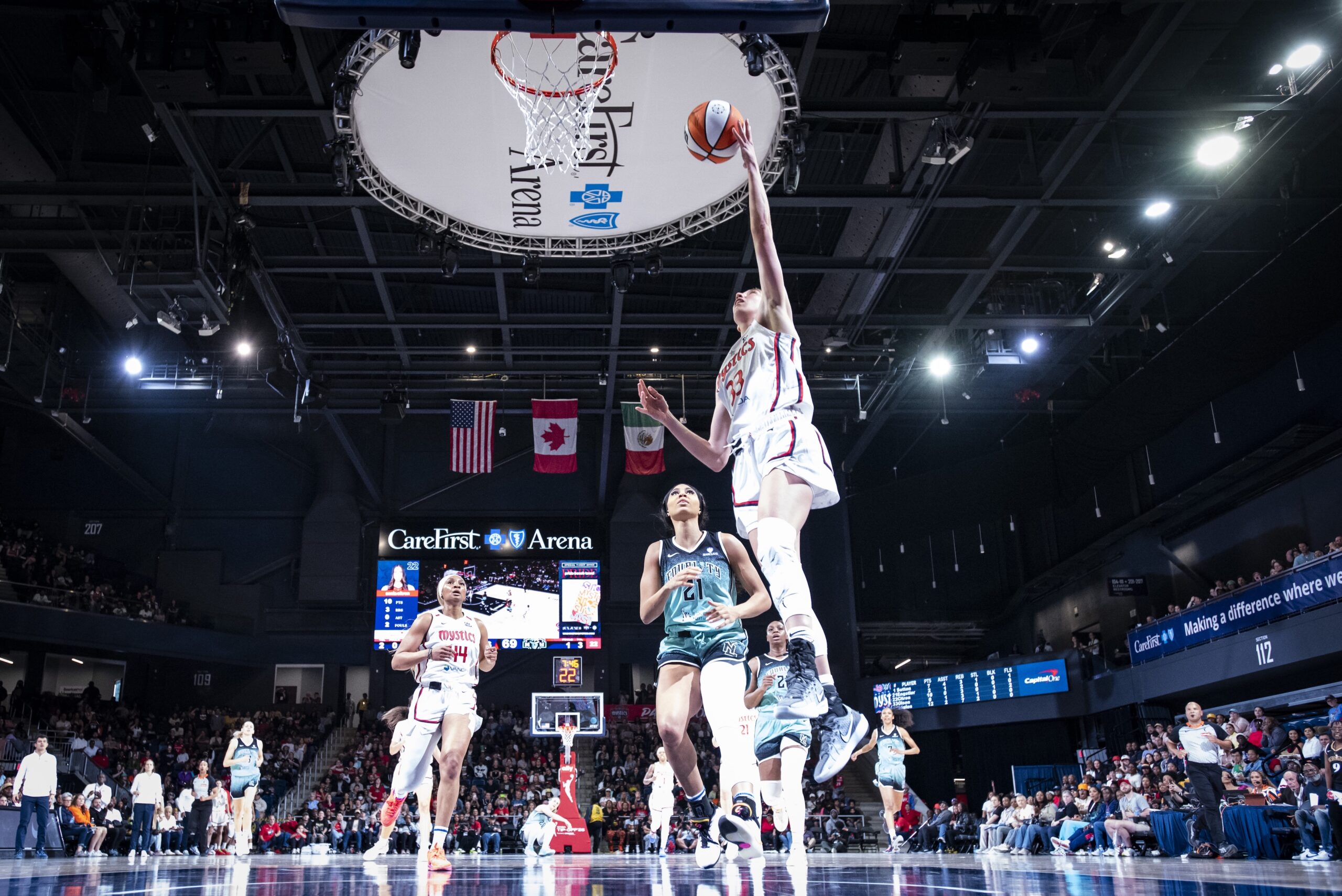 Washington Mystics guard Lucy Olsen jumps in the air and is about to shoot a left-handed layup. None of her teammates or the New York Liberty defense have caught up to her, and only two seconds have come off the shot clock.