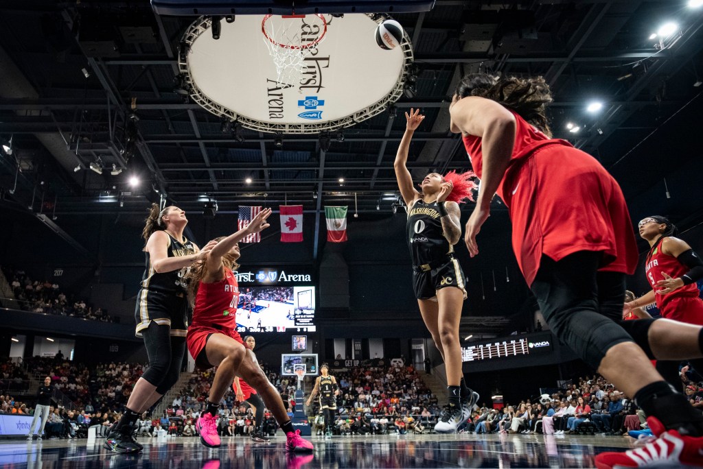 Washington Mystics center/forward Shakira Austin releases a floater in the lane. No Atlanta Dream defender is close enough to contest her shot. Two players try to get in rebounding position on the opposite side of the rim.