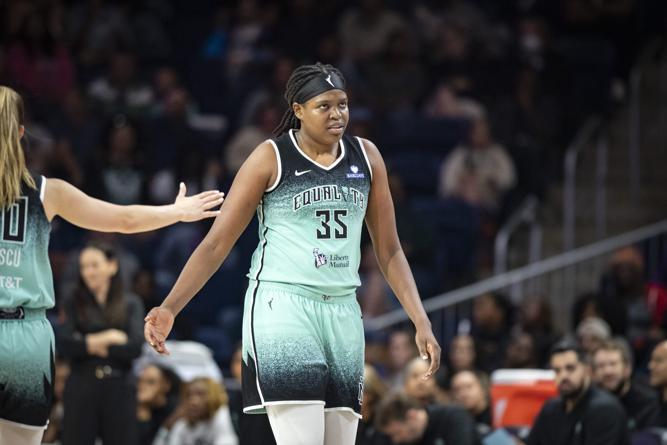 New York Liberty center Jonquel Jones has an intense look on her face as Sabrina Ionescu puts her hand out for Jones to slap.
