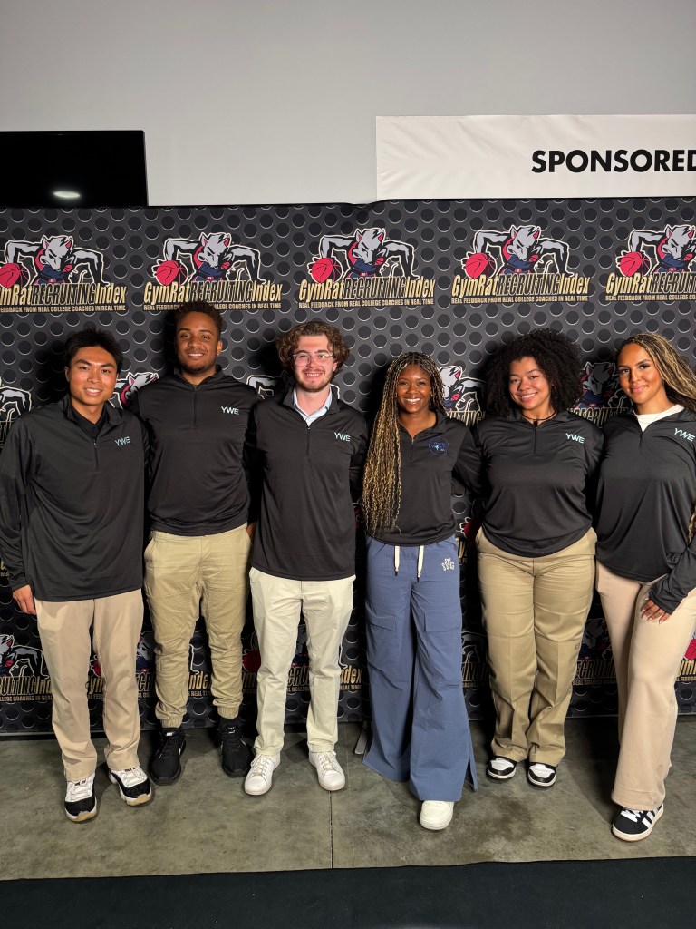 Isis Young poses with five students from her Your Media World Training program. They are standing shoulder to shoulder.