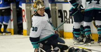 Goaltender Corinne Schroeder (30) adjusts her equipment on the ice