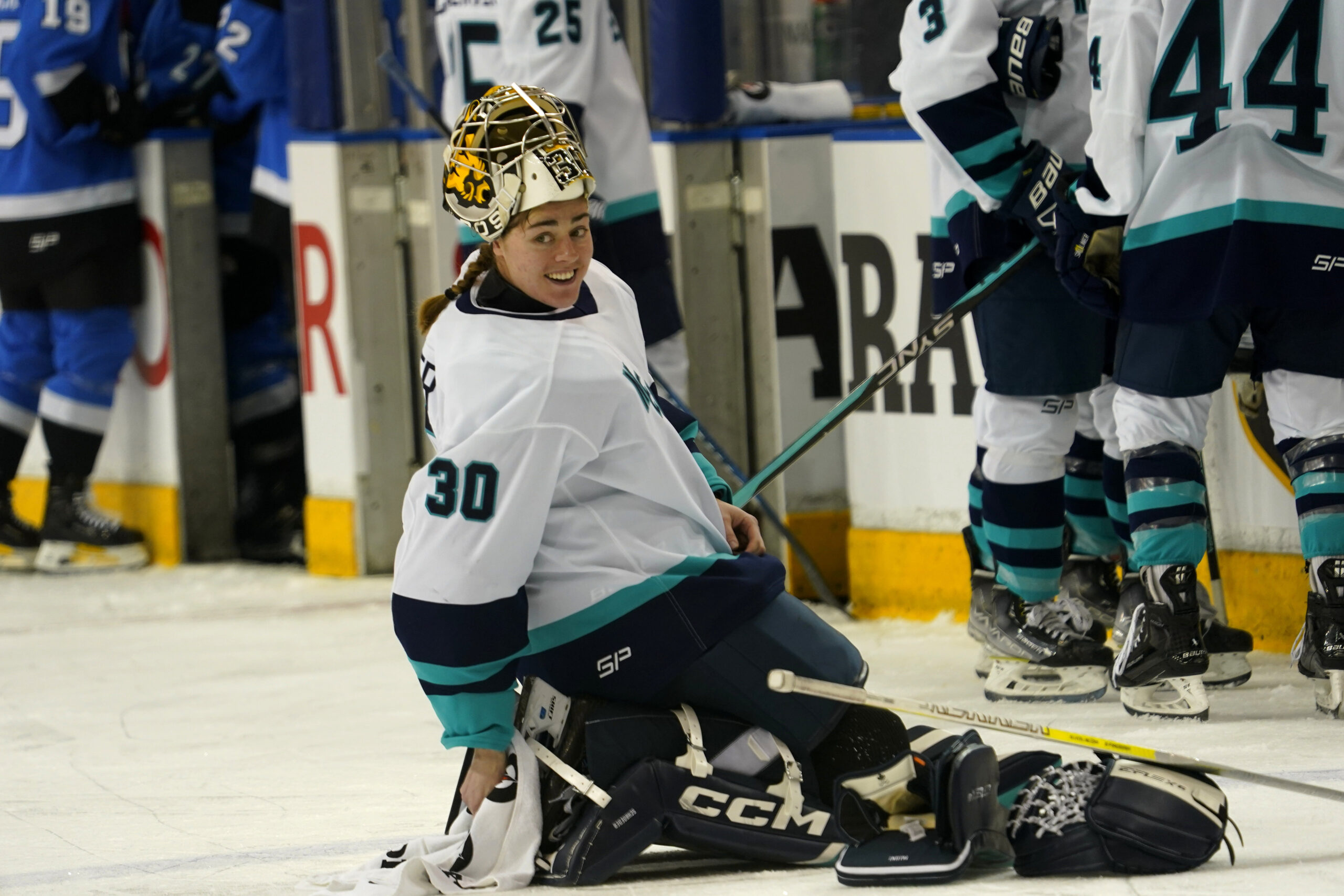 Goaltender Corinne Schroeder (30) adjusts her equipment on the ice