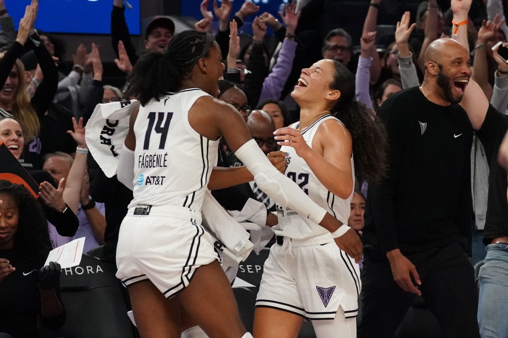 Golden State Valkyries center Temi Fagbenle congratulates guard Veronica Burton after Burton made a 3-pointer. Burton's eyes are closed and her head is tilted up toward the ceiling, and Fagbenle extends her arms toward Burton.