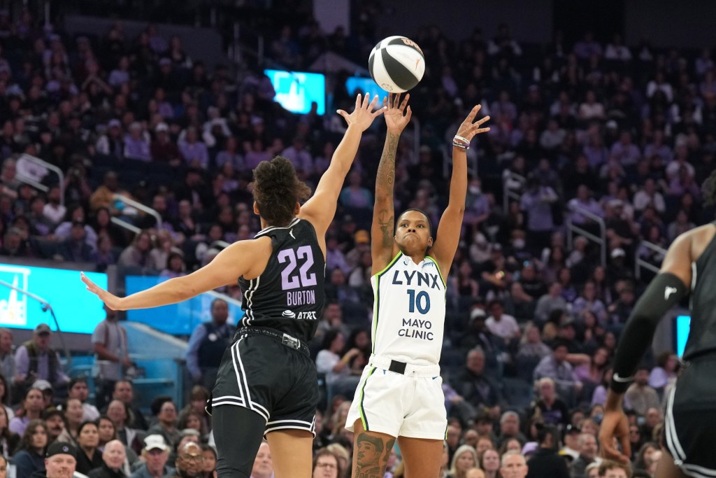 Minnesota Lynx guard Courtney Williams shoots a right-handed jump shot as Golden State Valkyries guard Veronica Burton stretches her right arm up to contest it.