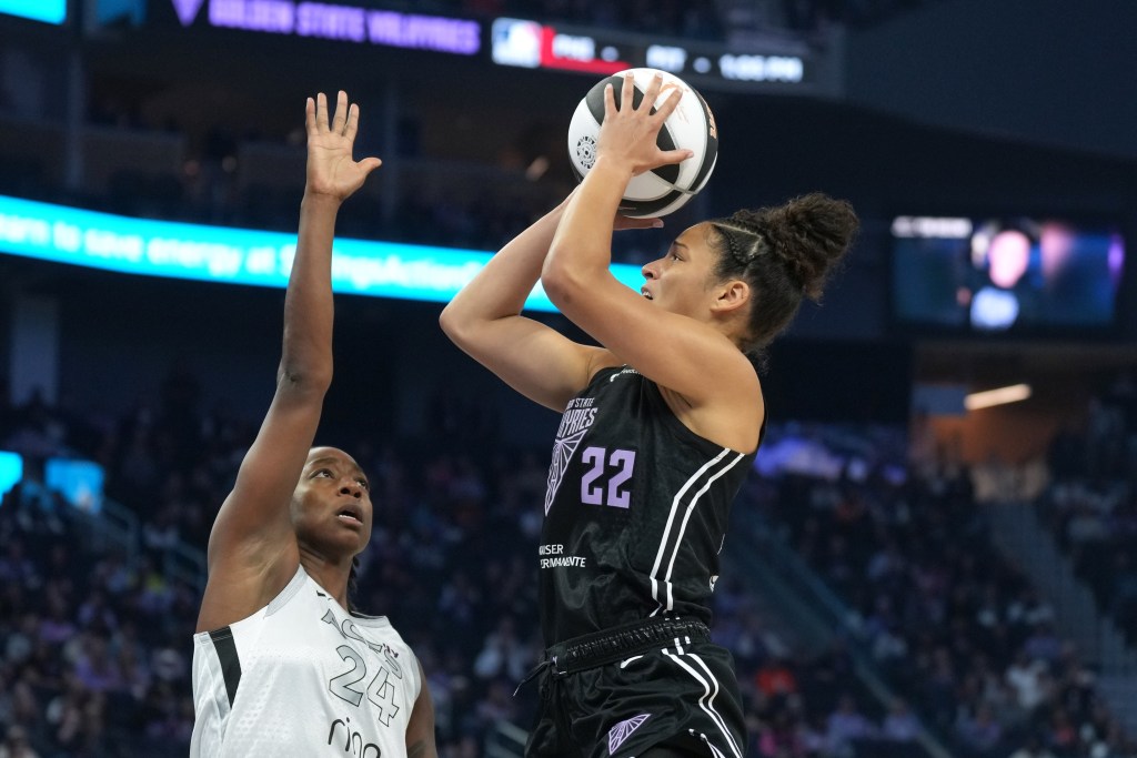 Golden State Valkyries guard Veronica Burton shoots against Las Vegas Aces guard Jewell Loyd. She is shown from the side, with Loyd on the left side of Burton.