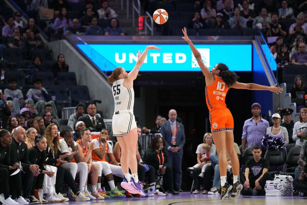 Golden State Valkyries forward Chloe Bibby shoots the ball against the Connecticut Sun. She is shown from the side with an out of focus crowd behind her.