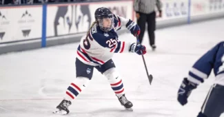Jada Habisch of the University of Connecticut saucers a pass across the ice.