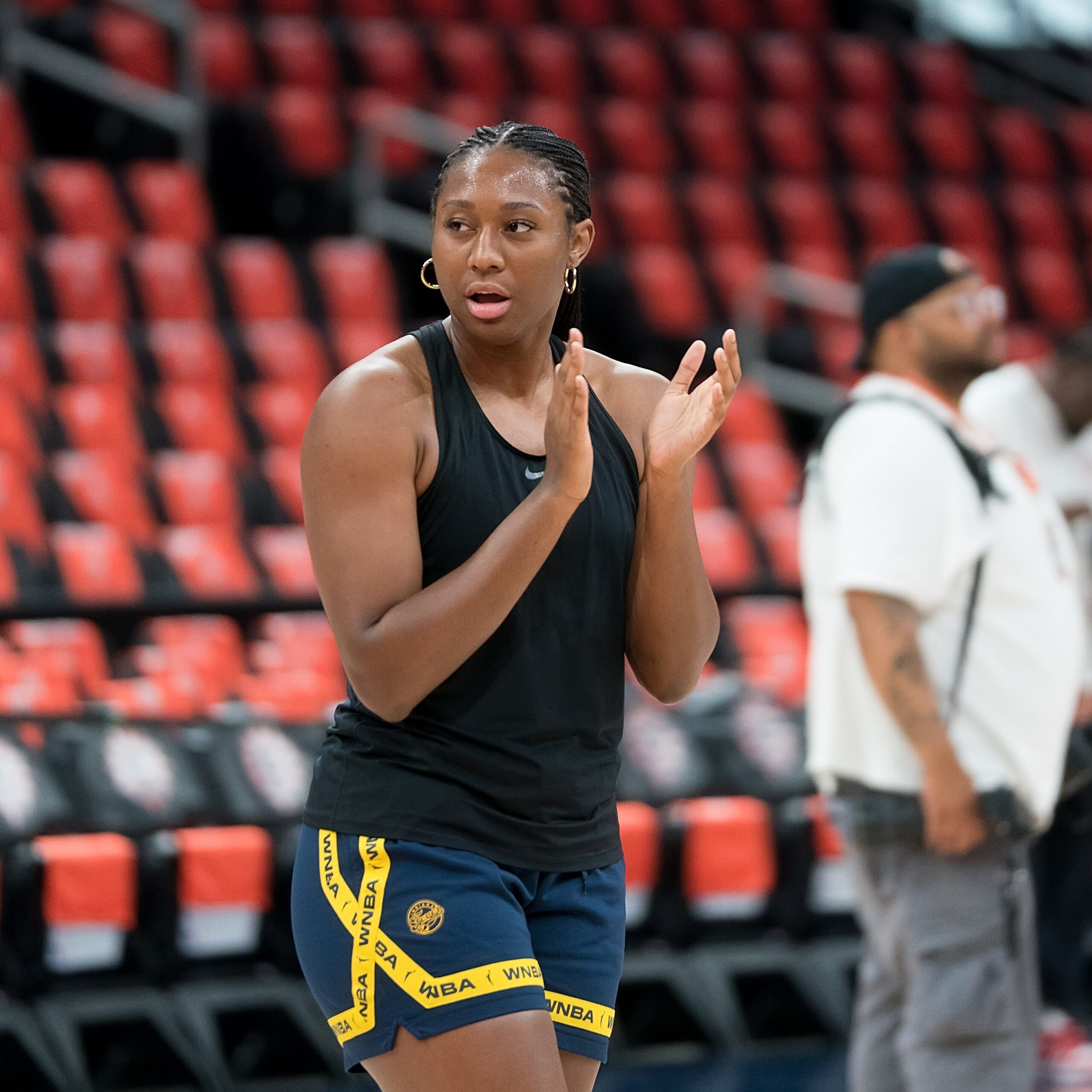 Aliyah Boston stands in pre-game clothes, clapping her hands together before the game begins