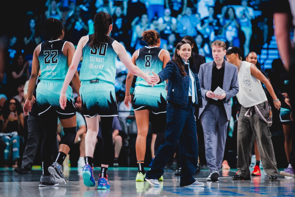 Liberty head coach Sandy Brondello gives a hand to her players Kennedy Burke, Breanna Stewart and Nyara Sabally as they come off the floor. They are met by assistant coach Olaf Lange and guard Natasha Cloud who was out with an injury.