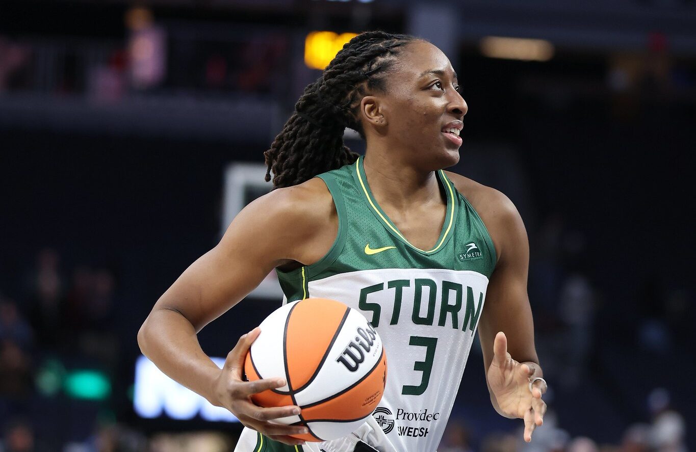 Before a game, Seattle Storm forward Nneka Ogwumike jogs with a basketball in her right hand and a slight smile on her face.