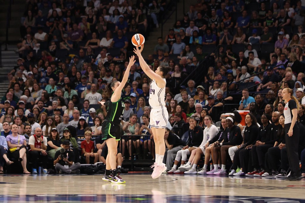 Golden State Valkyries forward Cecilia Zandalasini shoots a three pointer over Minnesota Lynx forward Bridget Carleton. They are shown from the side with a large crowd behind them.