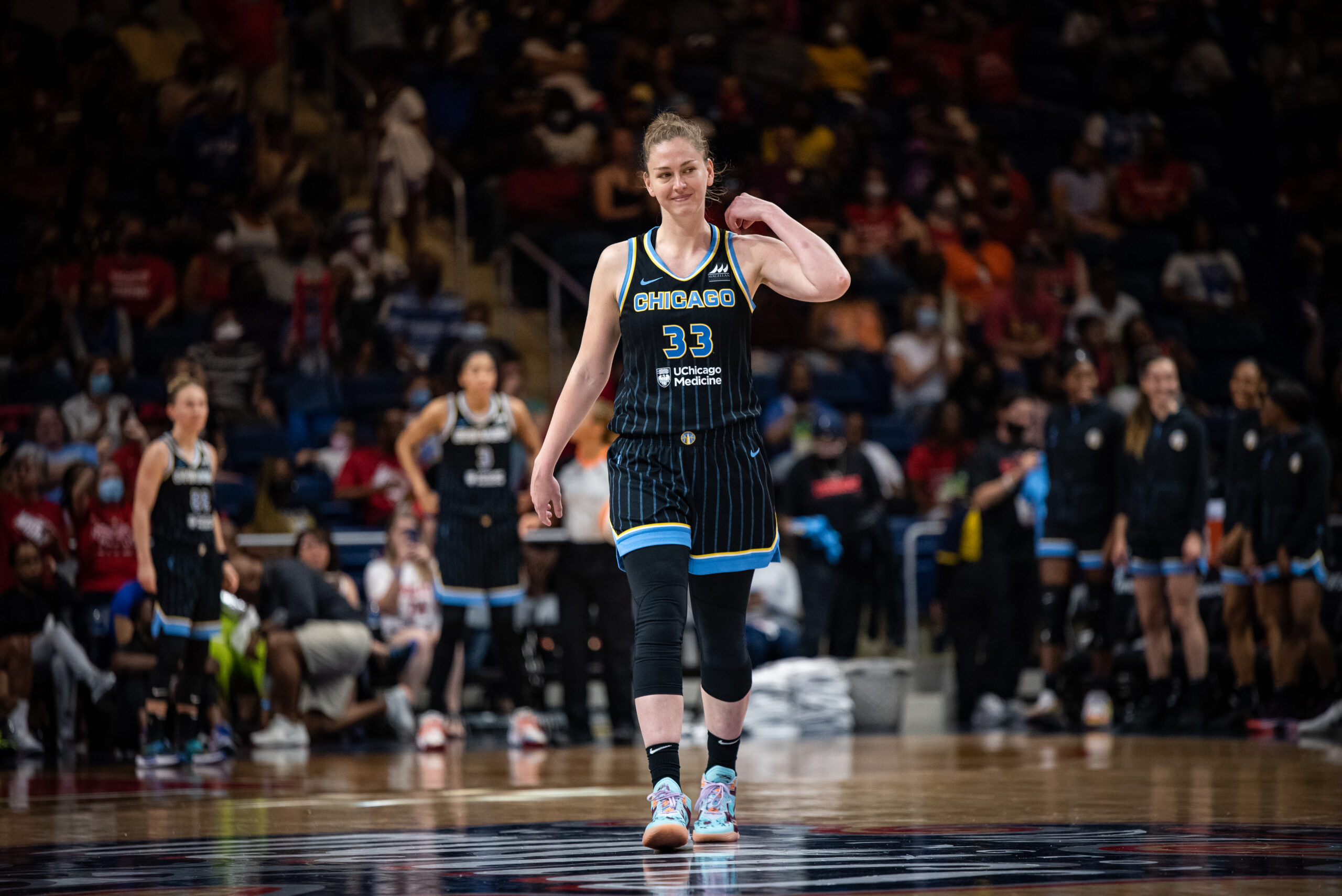 Emma Meeseman smiles while moving her left arm toward her head.