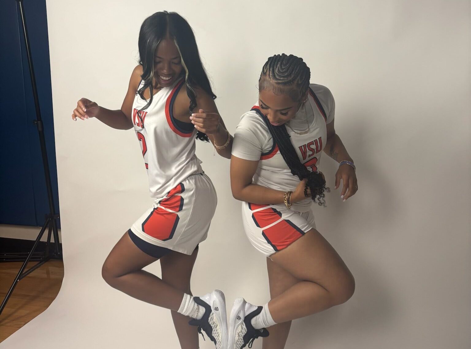 Tiyanna James (left) and Mihjae Hayes (right) playfully compare shoe sizes during a media day when they competed at Virginia State.