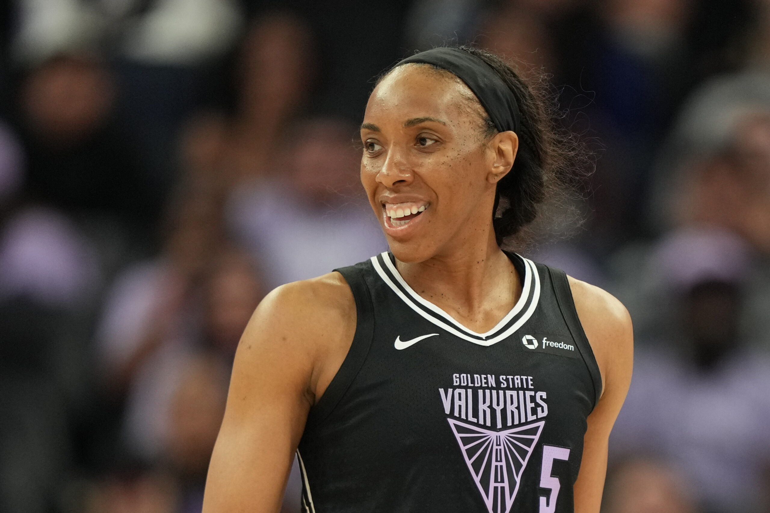 Golden State Valkyries forward Kayla Thornton is shown from the waist up, looking to her right and smiling during a game.