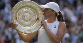 Iga Swiatek kisses the Wimbledon champion's trophy