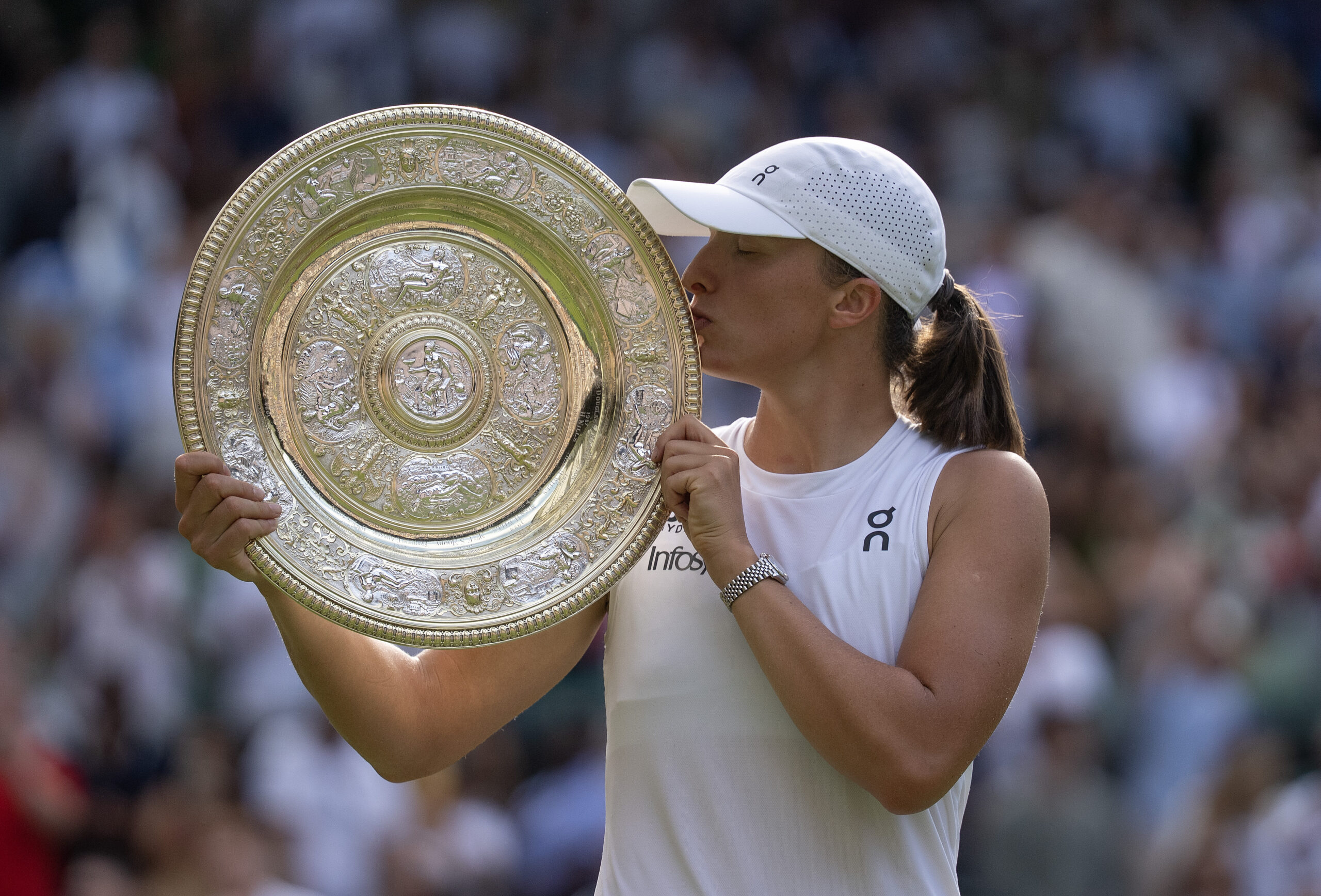 Iga Swiatek kisses the Wimbledon champion's trophy