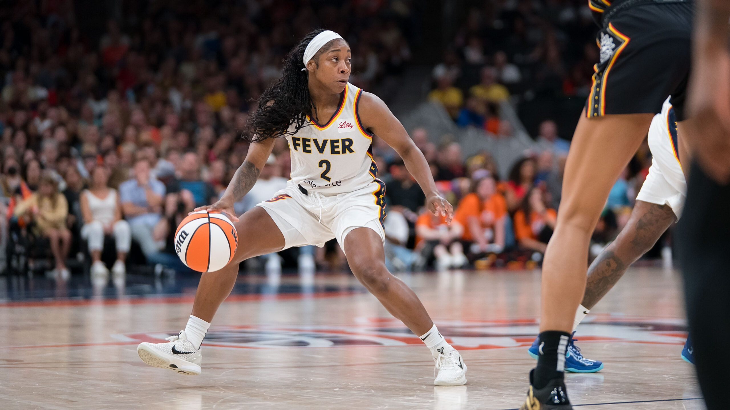 Indiana Fever guard Aari McDonald dribbles the ball with her right hand and looks off to her left.