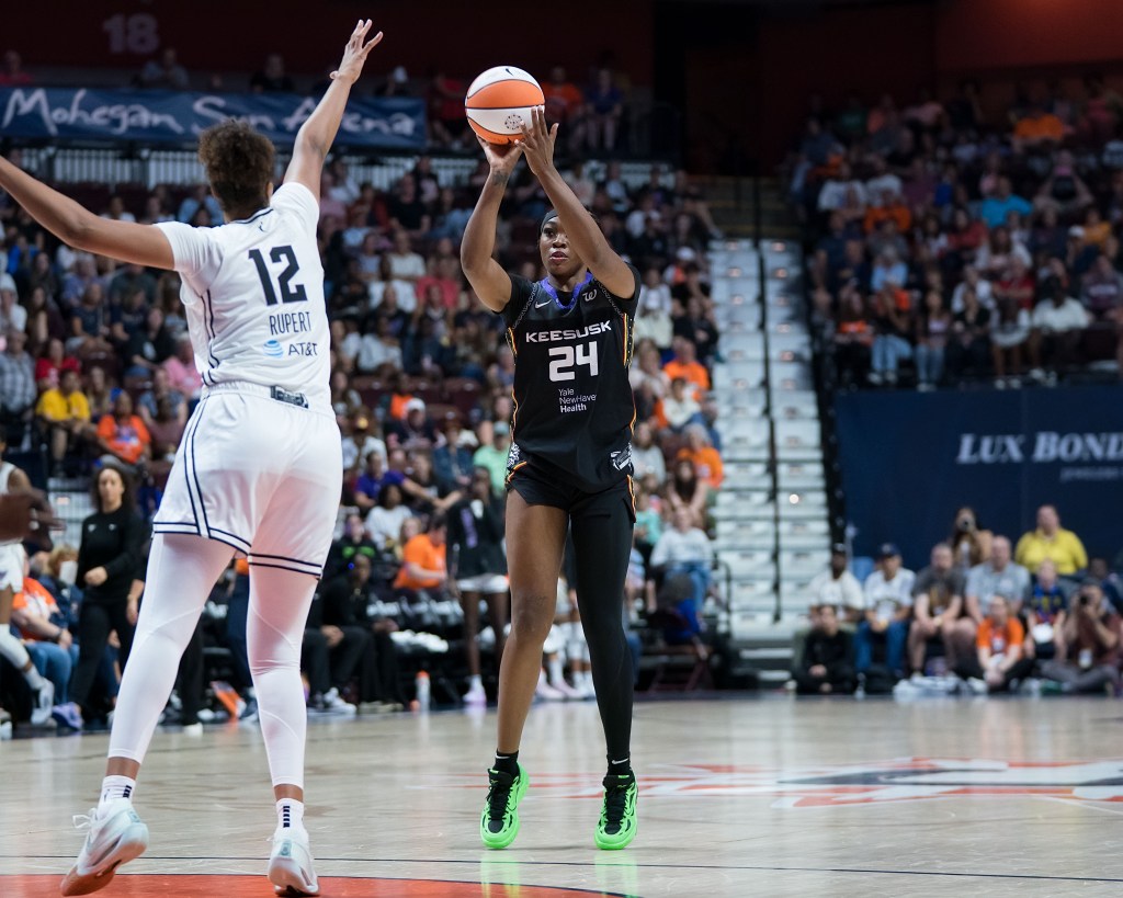 Connecticut Sun forward Aneesah Morrow shoots a 3-pointer as Golden State Valkyries center Iliana Rupert extends her right arm to contest the shot.