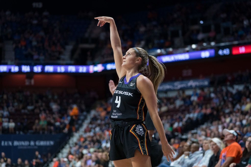 Connecticut Sun guard Jacy Sheldon is shown in profile. No other players are in the frame, and she holds her follow-through after a jump shot.