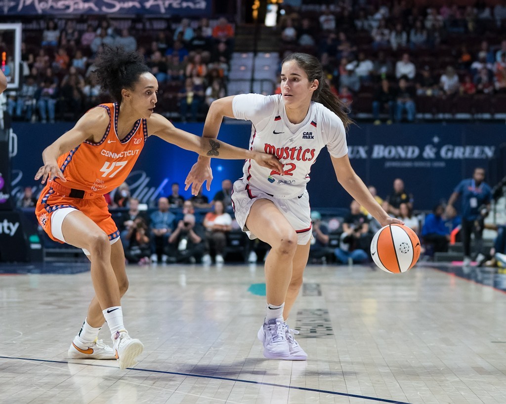 Washington Mystics guard Sonia Citron dribbles the ball with her left hand just outside the 3-point line. Connecticut Sun guard Leila Lacan slides her feet to try to stay with Citron.