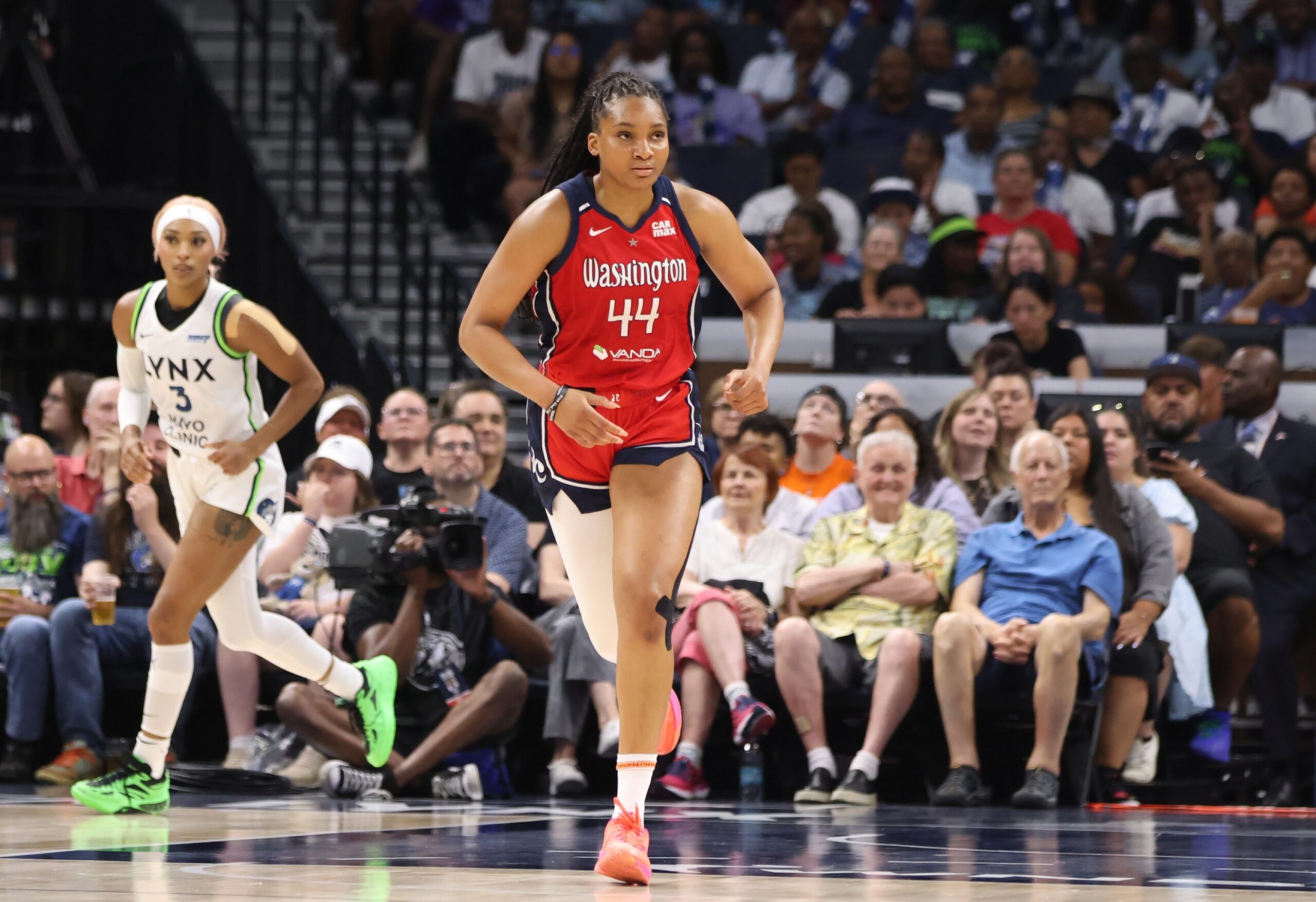 Washington Mystics forward Kiki Iriafen runs up the court without the ball. Her eyes are looking ahead of her and slightly to her left.