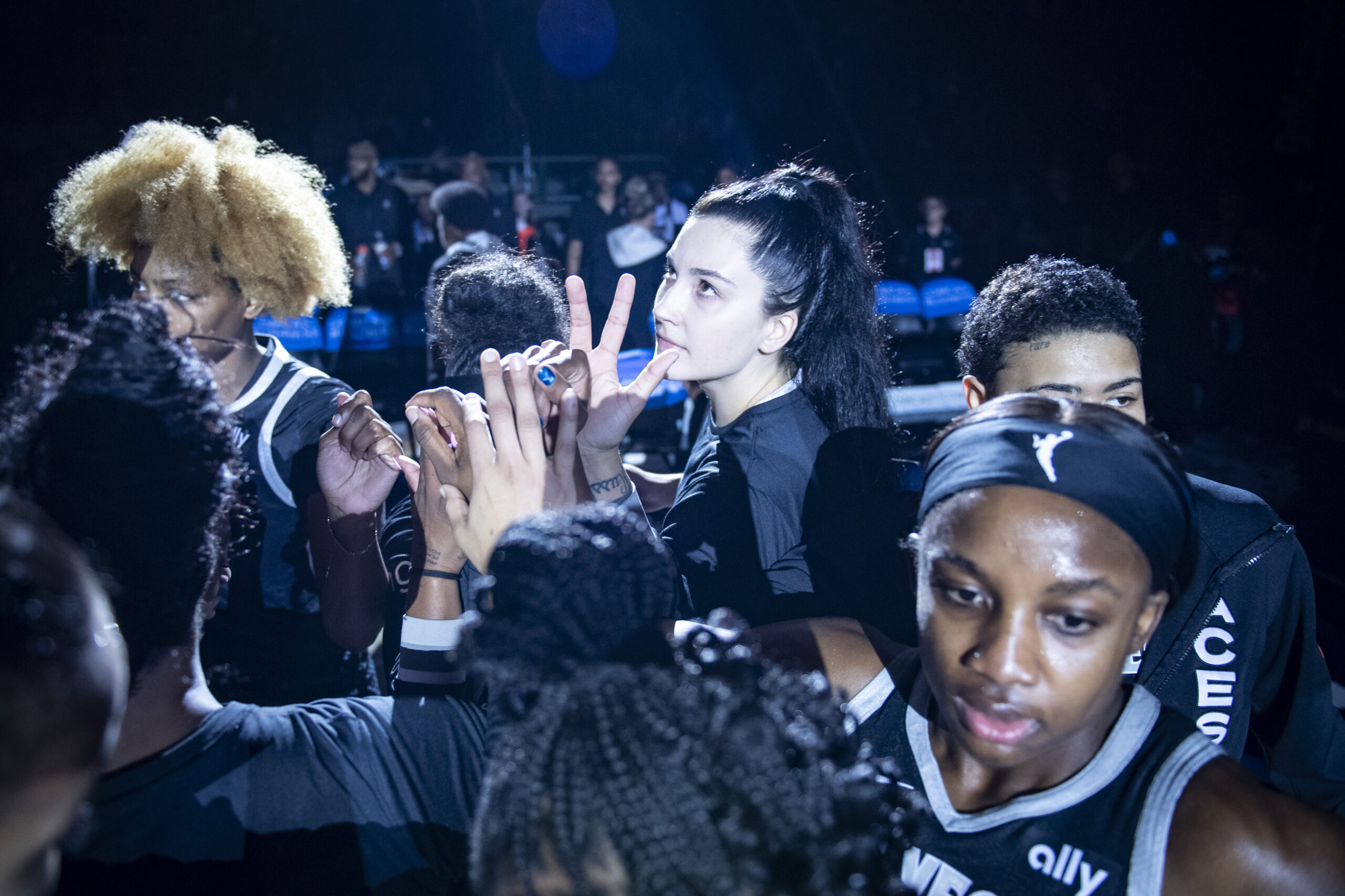 Jackie Young, Megan Gustafson, NaLyssa Smith, and the Aces bench do their team huddle before tip-off against the Washington Mystics.