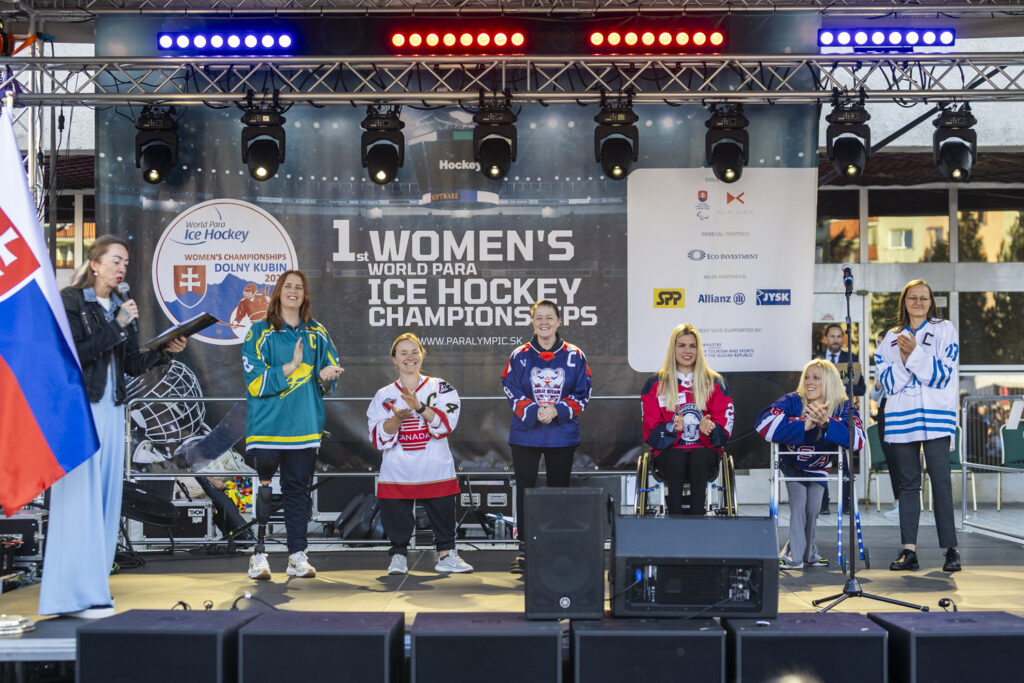 Captains from each of the six teams competing at the WPIH Women's World Championship pose on stage in team uniforms