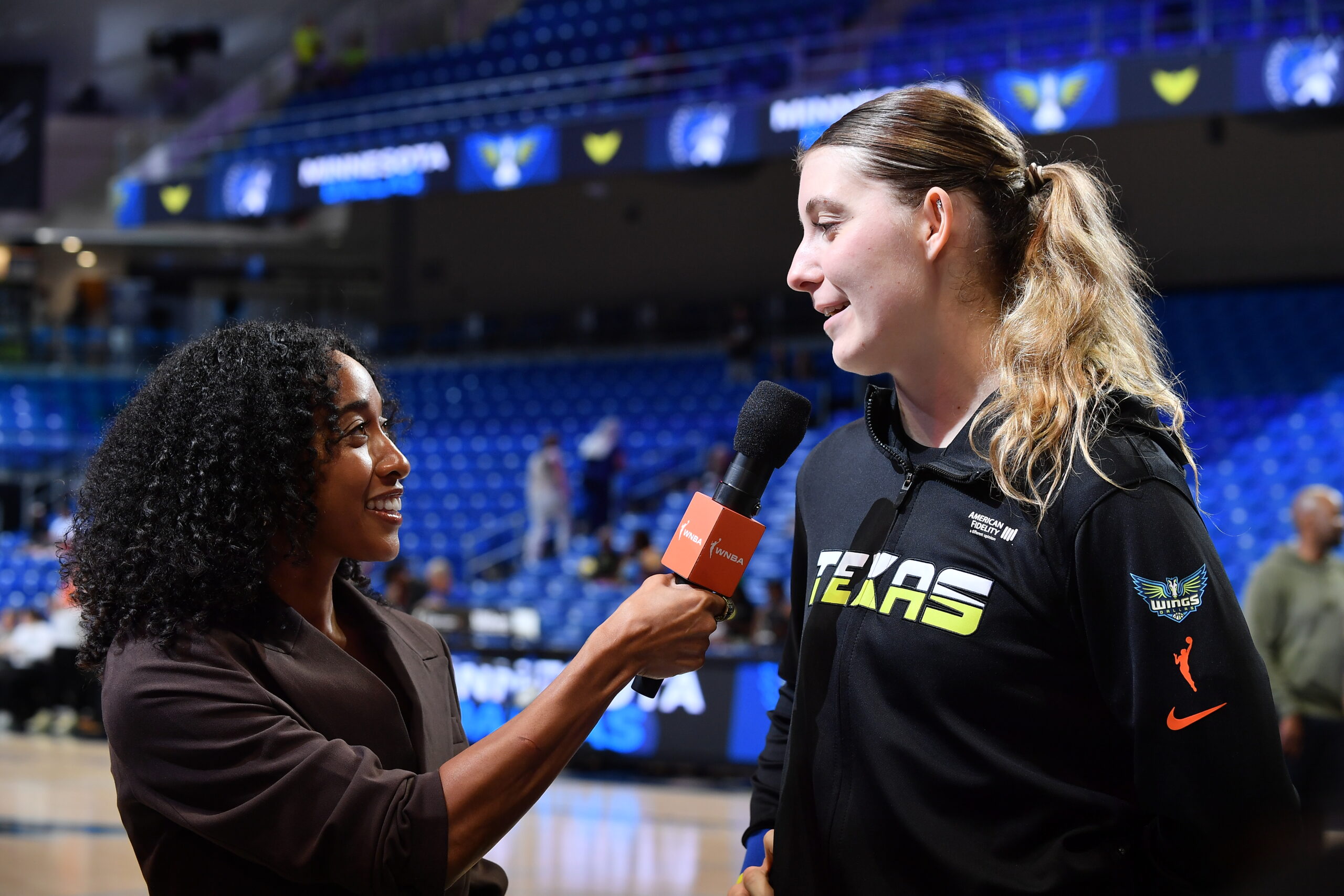 Tiffany Bias-Patmon interviews a Dallas Wings player before a game earlier this season.