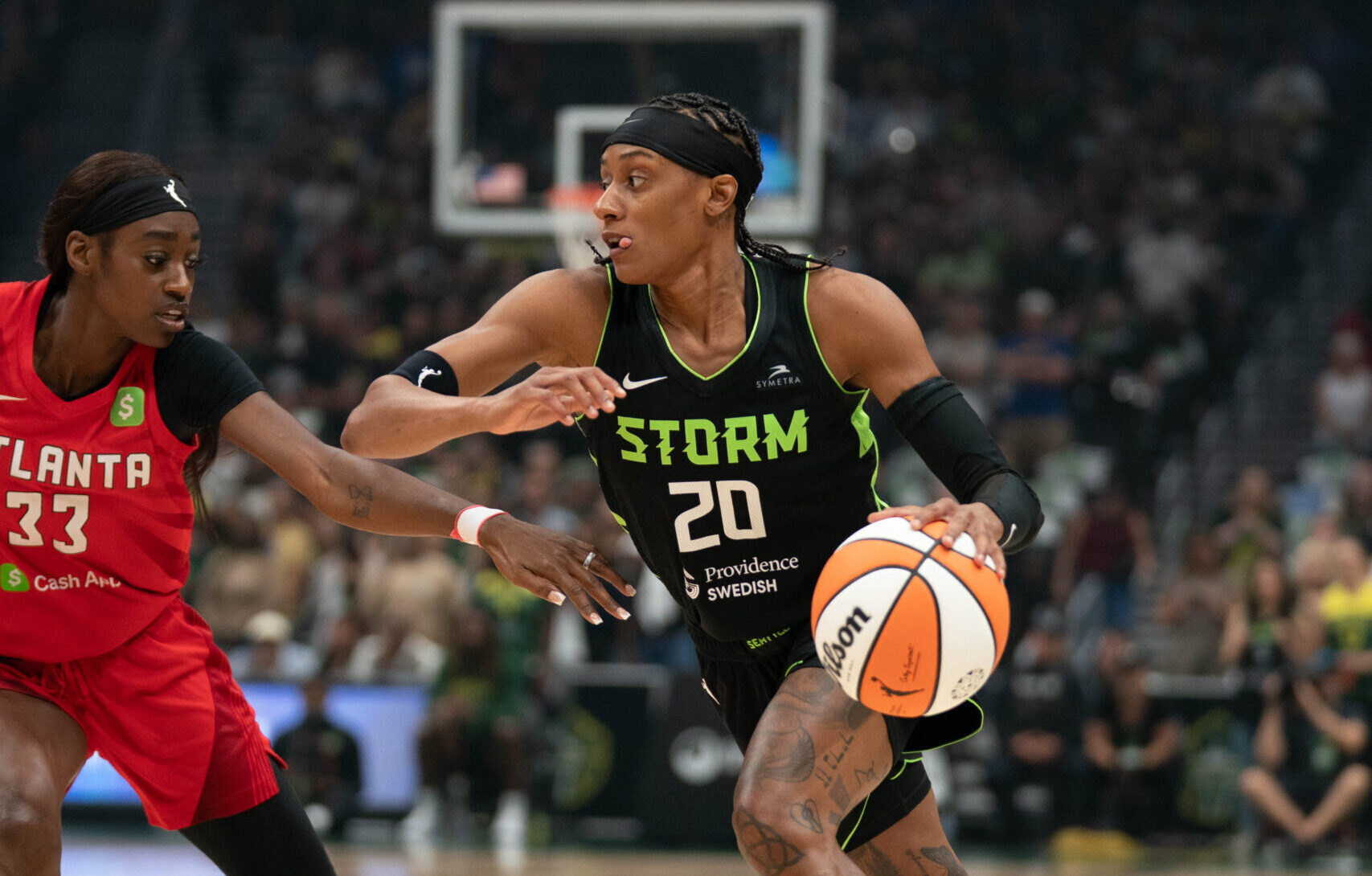 Brittney Sykes dribbles the ball and protects her space with an outward elbow as she drives at Maya Caldwell.