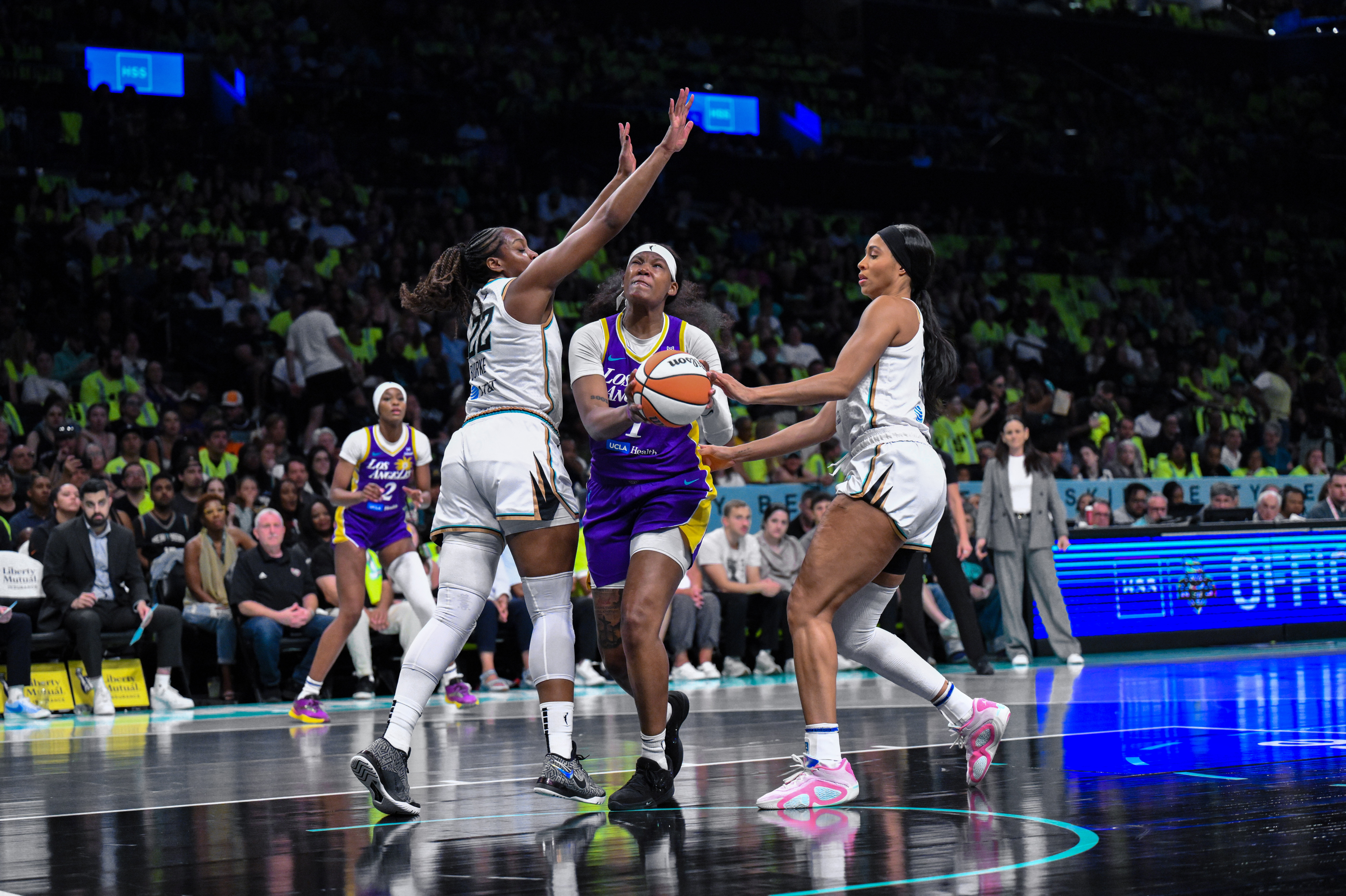 Sania Feagin drives to the basket and gathers the ball between New York Liberty defenders Isabelle Harrison and Kennedy Burke.
